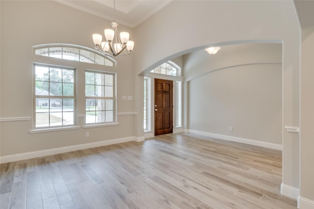 entryway with an inviting chandelier, light hardwood / wood-style flooring, and ornamental molding