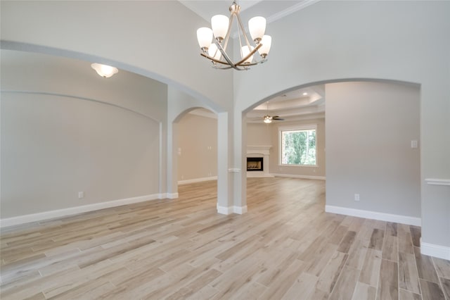 interior space featuring crown molding, ceiling fan with notable chandelier, and light hardwood / wood-style floors