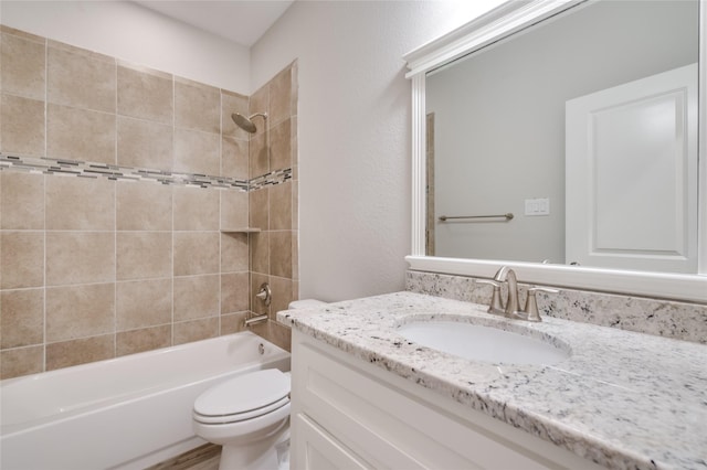 full bathroom with vanity, tiled shower / bath combo, and toilet