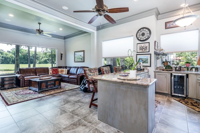 kitchen with pendant lighting, a kitchen breakfast bar, a center island, light stone counters, and wine cooler