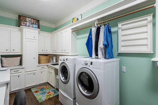 washroom featuring dark hardwood / wood-style flooring, ornamental molding, cabinets, and washing machine and clothes dryer