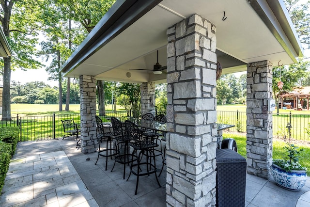 view of patio / terrace with a gazebo, ceiling fan, and a bar