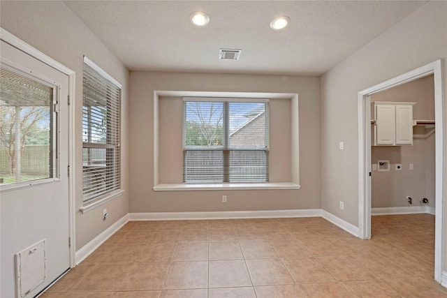 interior space featuring light tile patterned flooring and a textured ceiling