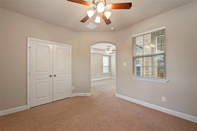 spare room featuring ceiling fan and light carpet