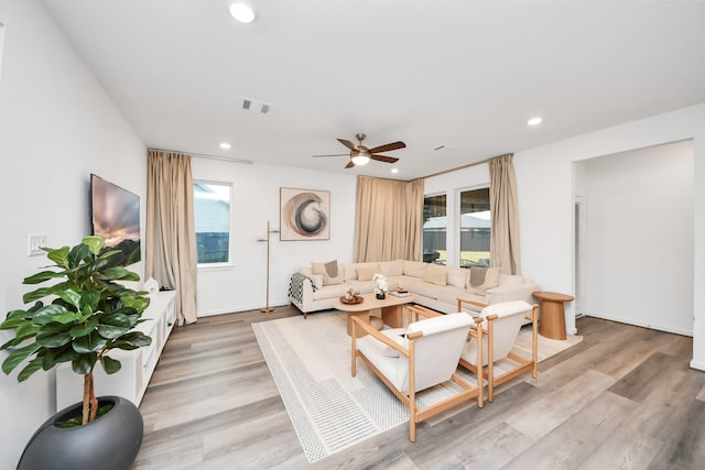 living room with light hardwood / wood-style flooring, a wealth of natural light, and ceiling fan