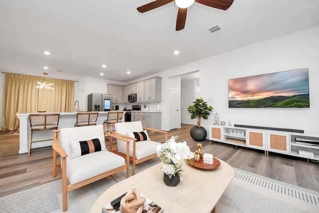 living room featuring wood-type flooring and ceiling fan