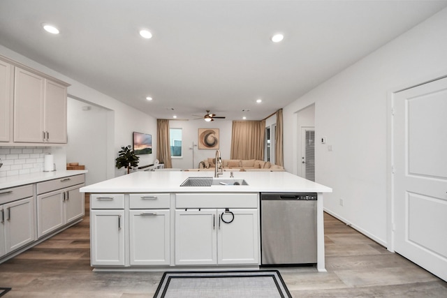 kitchen with sink, tasteful backsplash, stainless steel dishwasher, an island with sink, and ceiling fan