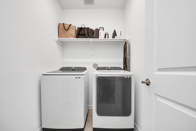 washroom with light tile patterned floors and washing machine and dryer