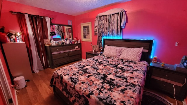 bedroom featuring hardwood / wood-style floors and a textured ceiling