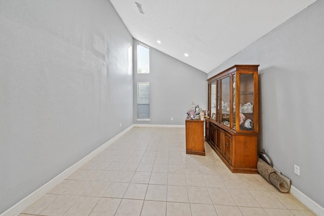 unfurnished room featuring lofted ceiling and light tile patterned floors