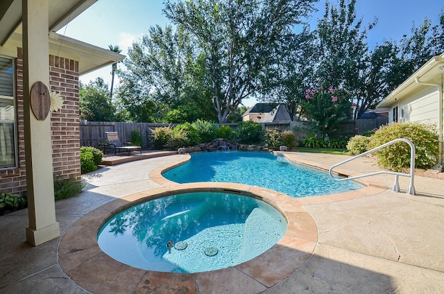 view of swimming pool with an in ground hot tub and a patio area