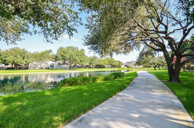 view of community featuring a water view and a lawn