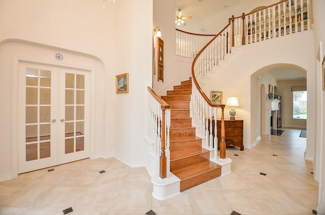 entrance foyer with a towering ceiling, light tile patterned floors, and french doors