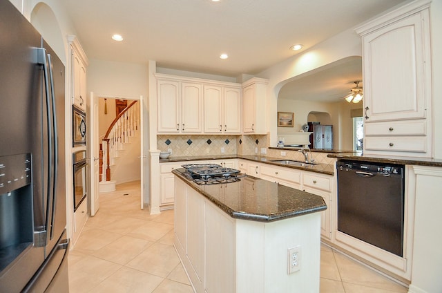 kitchen featuring sink, dark stone countertops, black appliances, light tile patterned flooring, and kitchen peninsula