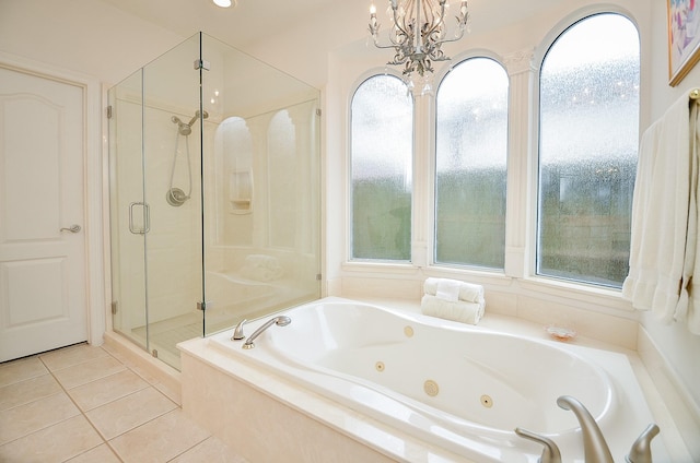 bathroom with tile patterned flooring, shower with separate bathtub, and an inviting chandelier