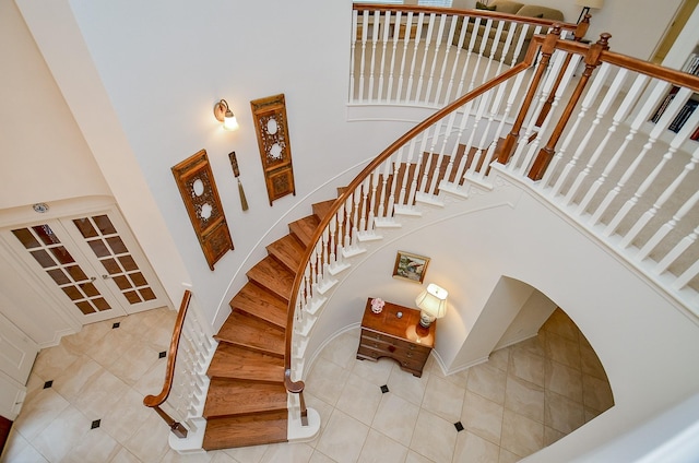 stairway featuring a high ceiling and tile patterned floors