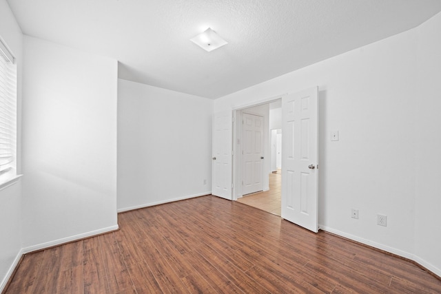 empty room with hardwood / wood-style flooring and a wealth of natural light