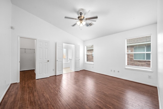 unfurnished bedroom featuring ensuite bath, ceiling fan, a spacious closet, vaulted ceiling, and a closet