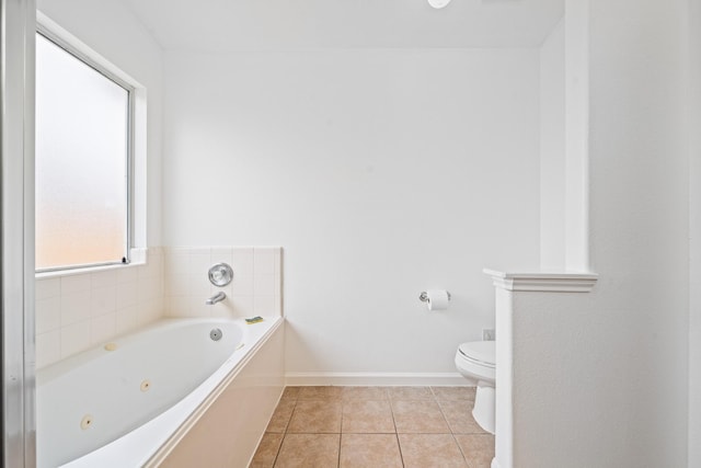 bathroom with a bath, tile patterned floors, and toilet