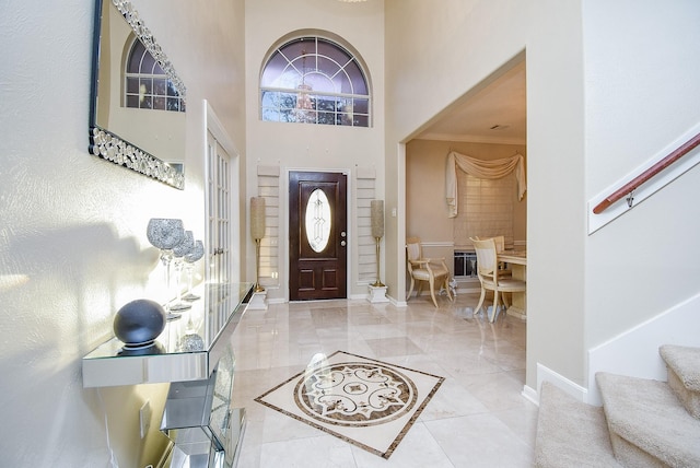 entrance foyer featuring crown molding and a high ceiling