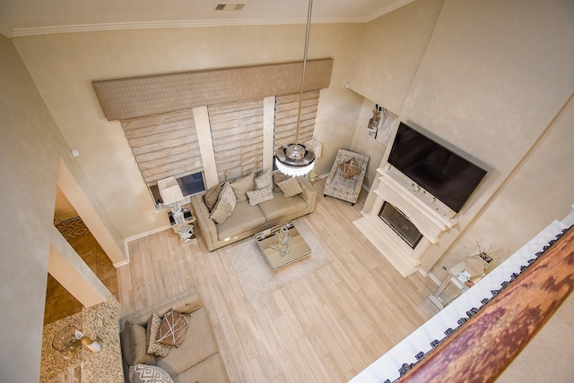 unfurnished living room featuring crown molding and wood-type flooring