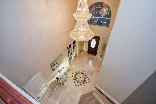 entrance foyer featuring a notable chandelier, light tile patterned floors, and a high ceiling