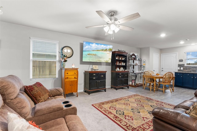 living room with a wealth of natural light, light colored carpet, and ceiling fan