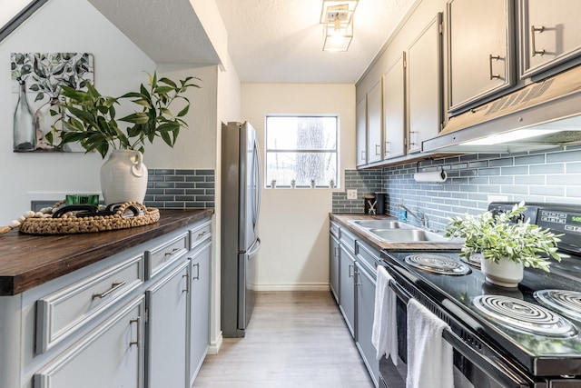 kitchen with sink, stainless steel fridge, gray cabinets, black range with electric stovetop, and a textured ceiling