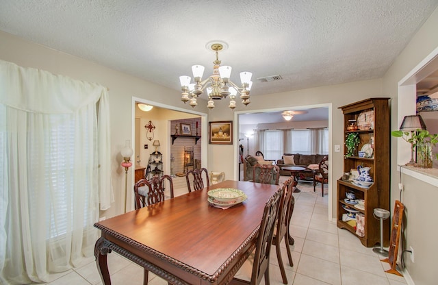 dining room with a notable chandelier, a textured ceiling, and light tile patterned flooring