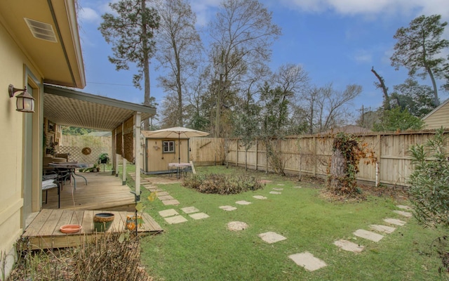 view of yard featuring a deck and a storage unit