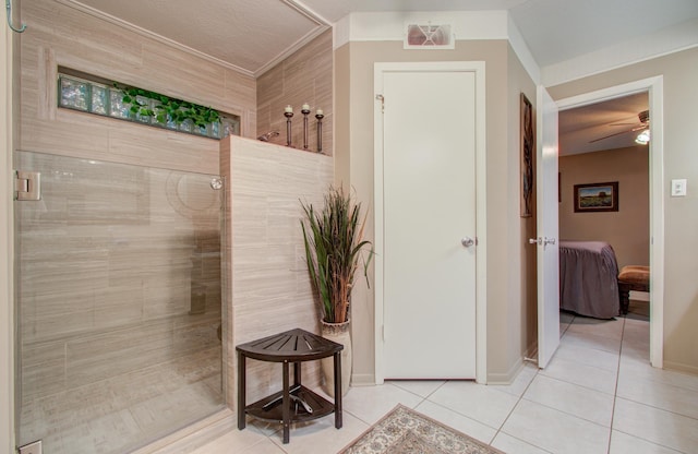 bathroom featuring tile patterned flooring and a tile shower