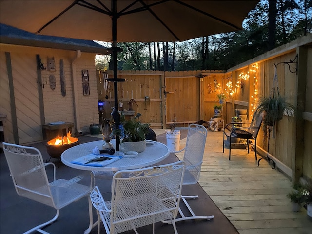 view of patio featuring a wooden deck and an outdoor fire pit