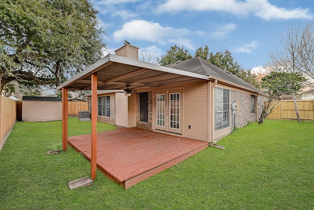 back of house with central AC, ceiling fan, a deck, and a lawn