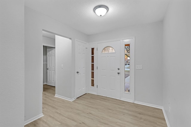 entrance foyer featuring a textured ceiling and light hardwood / wood-style floors