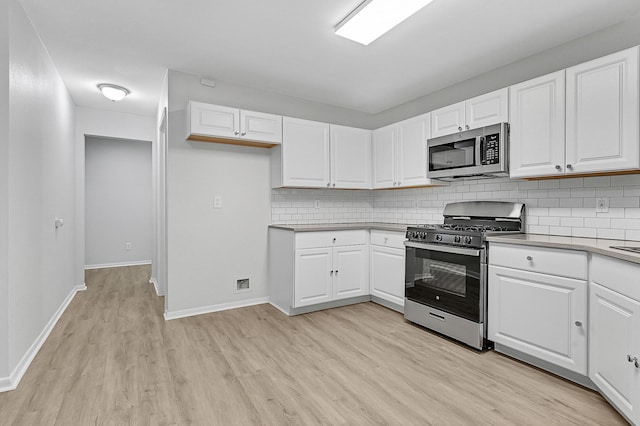 kitchen with appliances with stainless steel finishes, light wood-type flooring, decorative backsplash, and white cabinets