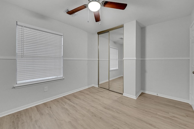 unfurnished bedroom with light hardwood / wood-style flooring, a closet, and ceiling fan