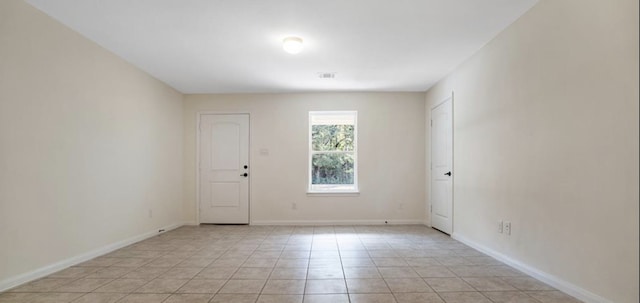 spare room featuring light tile patterned flooring