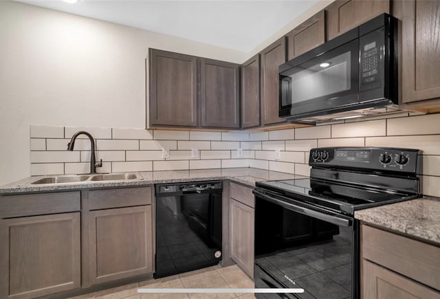 kitchen with light stone counters, sink, backsplash, and black appliances