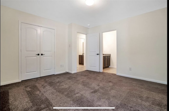 unfurnished bedroom with a closet, ensuite bath, and light carpet