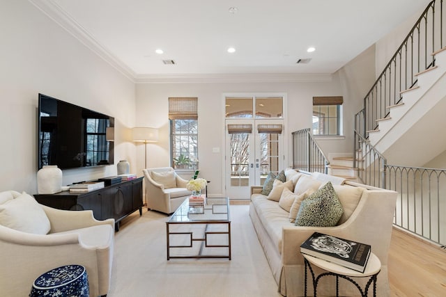 living room featuring crown molding, light hardwood / wood-style floors, and french doors