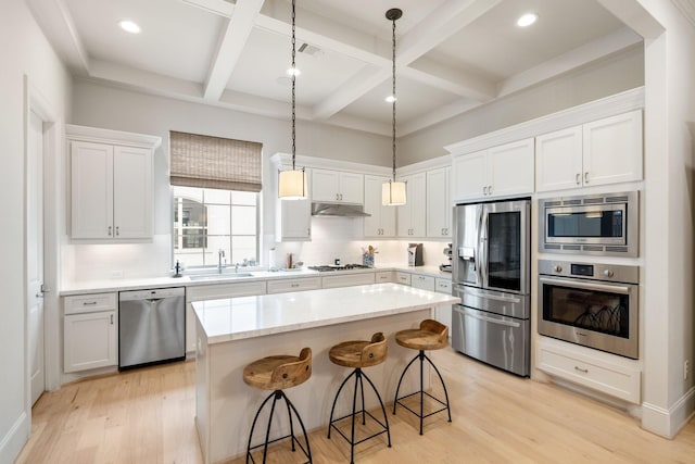 kitchen featuring white cabinetry, appliances with stainless steel finishes, a center island, and sink