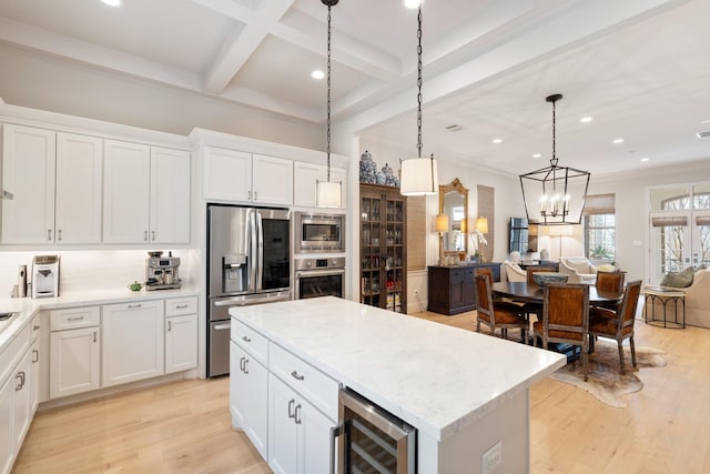 kitchen featuring pendant lighting, beam ceiling, stainless steel appliances, white cabinets, and beverage cooler