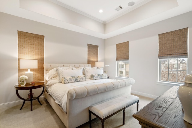 bedroom featuring crown molding, light colored carpet, and a tray ceiling