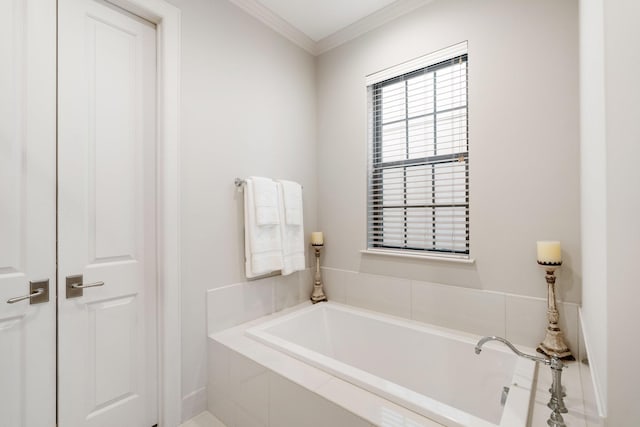 bathroom with ornamental molding and tiled bath