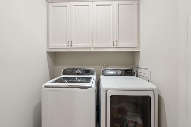 laundry area with cabinets and separate washer and dryer