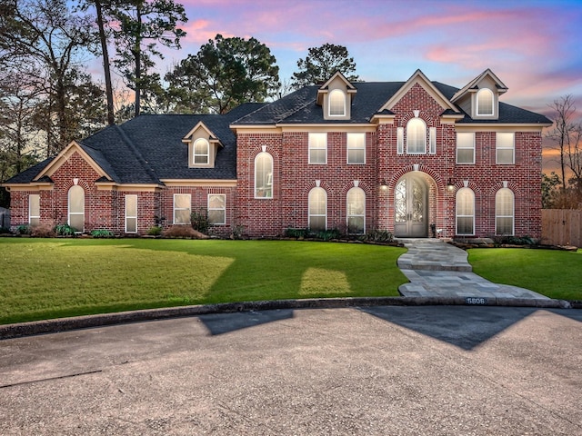 colonial-style house featuring a lawn