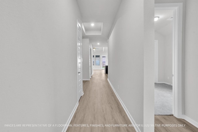 hall featuring light wood finished floors, visible vents, and baseboards