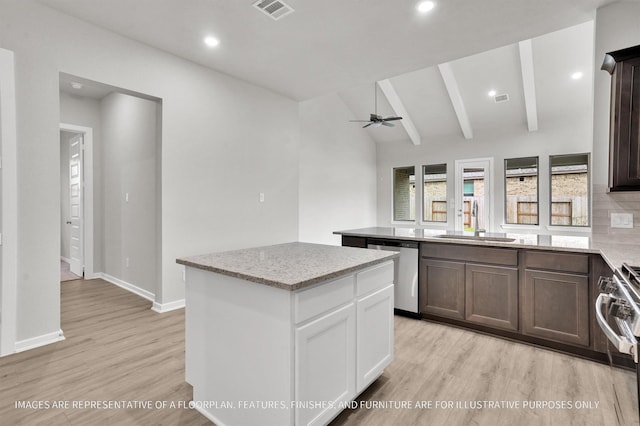 kitchen with visible vents, lofted ceiling with beams, a center island, stainless steel appliances, and a sink