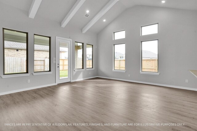 empty room featuring wood-type flooring, plenty of natural light, high vaulted ceiling, and beam ceiling