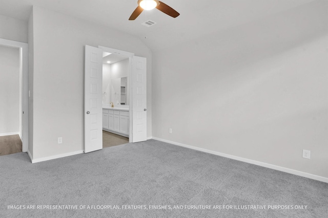 unfurnished bedroom with lofted ceiling, connected bathroom, carpet floors, and ceiling fan